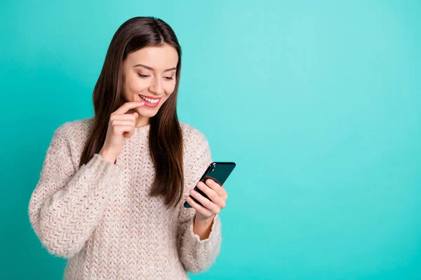 Gedrehtes Foto von inspirierten schönen positiven Mädchen mit ihrem Handy lesen Post aus Feednews tragen Strickpullover isoliert über türkisfarbenem Hintergrund — Stockfoto