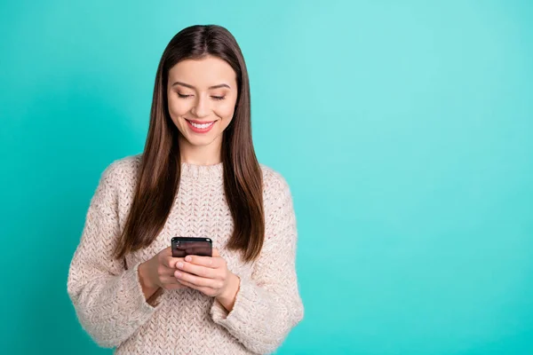 Портрет позитивной заинтересованной женщины, использующей свой мобильный телефон красный аккаунт в соцсетях новостей носить вязаный свитер изолирован на бирюзовом фоне — стоковое фото