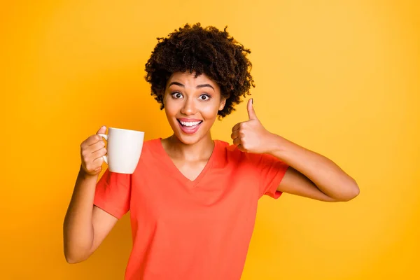 Photo of cheerful curly wavy trendy charming cute nice sweet black lady recommending you to taste new sort of coffee thumbing up isolated over vivid color background — Stock Photo, Image