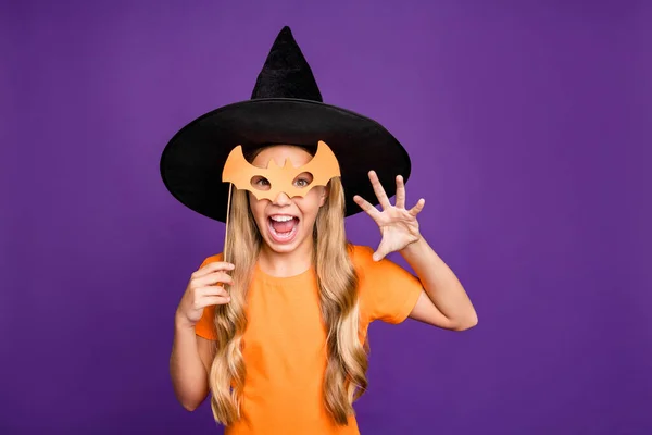 Foto de pequena bruxa senhora jogando paranormal criatura halloween tema partido segurando bastão papel vara desgaste laranja t-shirt chapéu de assistente isolado roxo cor fundo — Fotografia de Stock