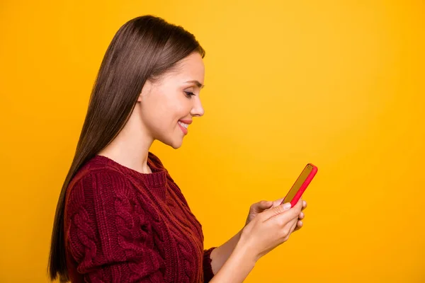 Foto lateral de perfil de senhora alegre em camisola borgonha segurando tecnologia moderna isolada sobre fundo amarelo — Fotografia de Stock