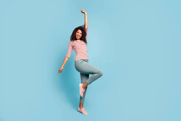 Foto em tamanho completo de engraçado escuro pele senhora fresco dia ensolarado desfrutar de primavera humor dançando louco levantar mão desgaste casual roupas isolado pastel azul cor fundo — Fotografia de Stock