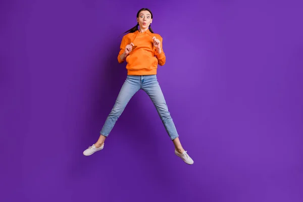 Фотографія повного розміру смішних фанк-міленіалів дівчина стрибає насолоджуватися відпусткою, переносячи сучасне вбрання джинсові білі кросівки ізольовані на яскравому кольоровому фоні — стокове фото