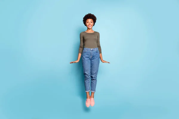 Foto de comprimento total de excitado senhora pele escura saltando alto regozijo com estudante viagem de baixo custo no exterior usar roupa casual isolado pastel azul cor fundo — Fotografia de Stock