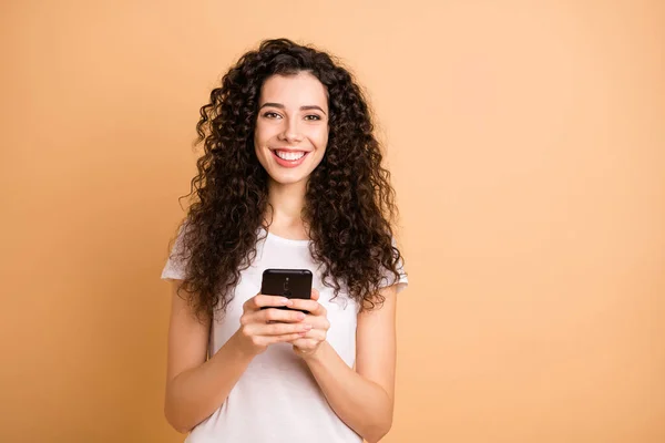 Foto de uma senhora incrível segurando as mãos do telefone viciado feednews pessoa verificando seguidores usam roupas casuais brancas isolado bege fundo cor pastel — Fotografia de Stock