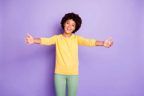 Foto de ondulado rizado moda bastante dulce encantador millennial invitando a abrazar su sonrisa con pantalones verdes pantalones aislados sobre fondo de color pastel púrpura — Foto de Stock