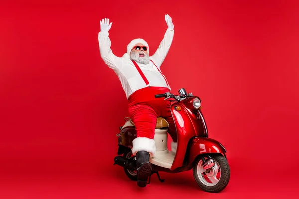 Portrait of his nice bearded cheerful fat big belly Santa hipster riding retro motor bike rising hands up having fun fooling isolated on bright vivid shine vibrant red color background — Stok Foto