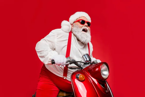 Porträt seiner schönen dicken Bauch grauhaarig fröhlich funky Weihnachtsmann Hipster Reiten Retro-Motorrad verbringen Winterurlaub isoliert auf hellem lebendigen Glanz leuchtenden roten Hintergrund — Stockfoto