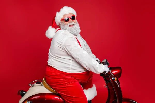 Profil vue de côté portrait de belle barbu joyeux drôle funky père Santa St Nicholas équitation moto livrer des commandes de magasin dépêchez-vous isolé sur brillant vif fond de couleur rouge vif — Photo