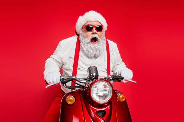 Portret ładny atrakcyjny brodaty szalony wesoły wesoły wesoły zabawny funky Santa jazda na motocyklu dostarczanie zamówień sklepowych pospiesz się odizolowany na jasny żywy połysk żywy czerwony kolor tła — Zdjęcie stockowe