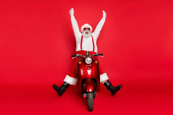 Retrato de su agradable atractivo despreocupado loco barbudo alegre alegre alegre divertido funky Santa bicicleta de montar entregando órdenes que se divierten aislados sobre brillante brillo vivo vibrante color rojo fondo —  Fotos de Stock