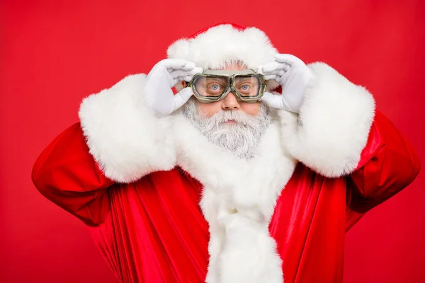 Close up photo of focused funky cool santa claus fix his goggles before rocket flight wear white gloves cap isolated over red color background — Stock Photo, Image