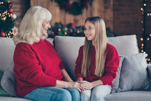 Porträtt av trevlig attraktiv vacker söt söt tillgiven charmig glad glad mormor barnbarn sitter på divan tillbringa semester hålla händer på industriell loft stil interiör hus inomhus — Stockfoto