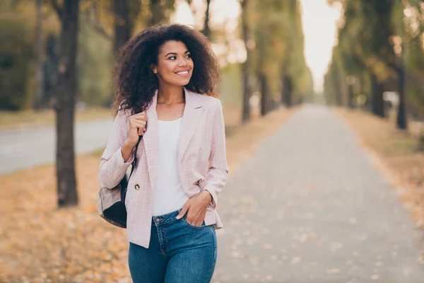 Photo of amazing pretty dark skin curly lady uśmiechnięty przystojny facet walking park po wykładach uczelni trzymać plecak ciepły sezon jesień nosić dżinsy kurtka na zewnątrz — Zdjęcie stockowe