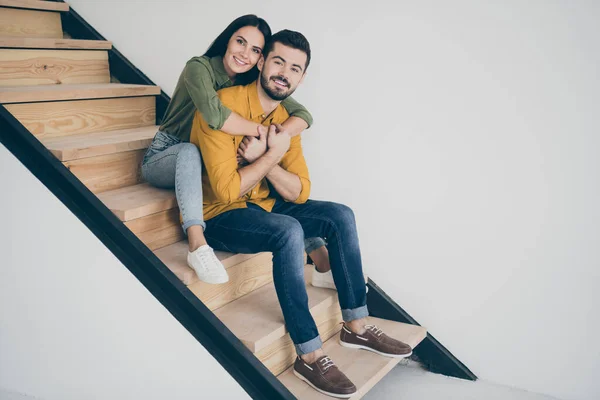フルボディプロフィール写真のハンサムな男と彼の可愛いです女性座って快適な上の階段で現代的な部屋室内に移動する新しいフラット一緒にカジュアル服を着る — ストック写真
