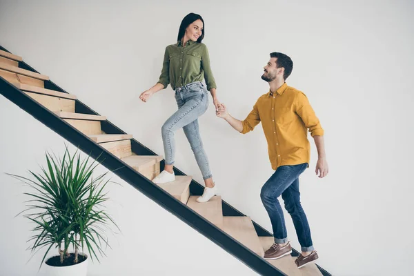 Exploremos este lugar. Foto de perfil de tamaño completo del chico guapo y su hermosa dama caminando al dormitorio subir escaleras en acaba de comprar piso moderno en el interior usar ropa casual —  Fotos de Stock