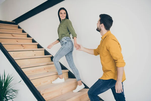 미남 남자와 미녀가 계단을 오르는 모습, 실내에 있는 평상복을 입고 현대적 인 스타일의 실내를 새로 단장하는 모습 — 스톡 사진