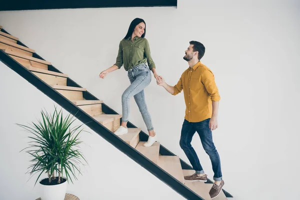 미남 남자와 미녀 가 침실로 걸어오는 모습이 담긴 전체 사진 . 실내에서 평상복을 입고 현대적 인 아파트 계단을 오르는 모습. — 스톡 사진