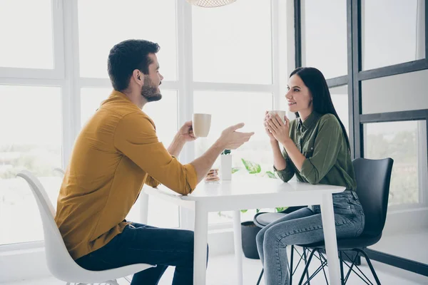 Profile photo of handsome guy and his pretty lady looking tender eyes drinking hot beverage sitting chairs opposite in modern interior light cafeteria indoors wear casual clothes — Stock Photo, Image