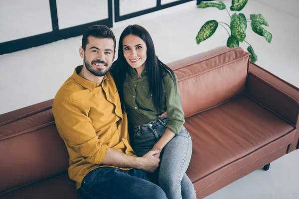 Felices juntos. Foto de vista de ángulo alto del increíble chico y la señora que se divierten mejor fin de semana de la vida estudiantil abrazando sofá sentado en el interior moderno albergue plano usar ropa casual —  Fotos de Stock