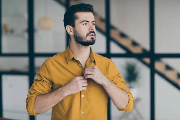Closeup photo of handsome business guy preparing for important seminar buttoning yellow shirt standing in stylish interior apartments office building indoors — Stok fotoğraf
