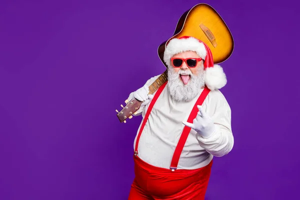 Retrato dele ele agradável alegre impertinente alegre alegre legal barbudo grosso gordura Papai Noel carregando guitarra mostrando sinal de chifre se divertindo isolado sobre brilhante vívido brilho vibrante violeta lilás fundo — Fotografia de Stock