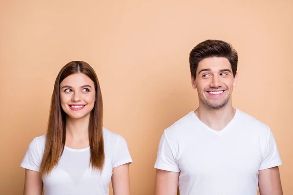 Primo piano ritratto del suo lui lei bella attraente bella allegra allegra coppia modesta bianco t-shirt guardando l'un l'altro isolato su sfondo di colore beige pastello — Foto Stock