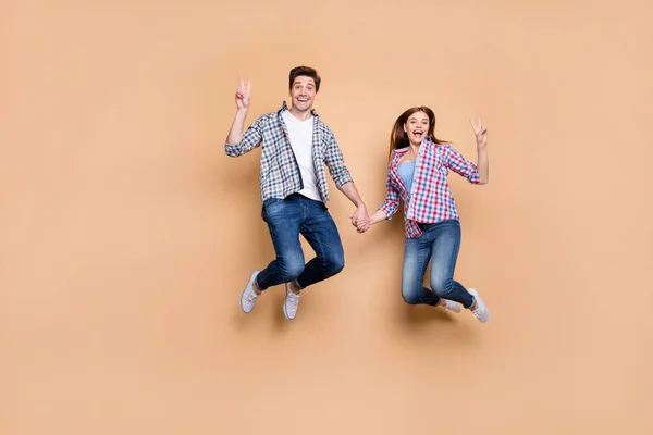 안녕 하 세요. 손을 높이 들고 점프하는 두 사람의 사진 전체 길이는 v-sign 상징을 보여 주고 있다. — 스톡 사진