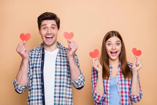 Foto de ruiva alegre casual elegante bonito encantador belo casal regozijando-se sobre ter recebido novos cartões postais vermelhos pequenos isolados sobre cor bege fundo pastel — Fotografia de Stock