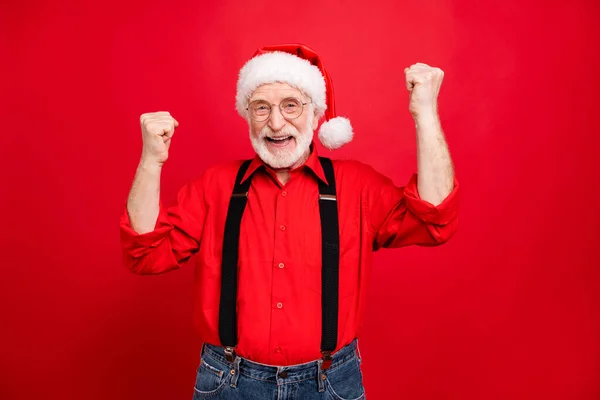 Portret van zijn he nice trendy vrolijke vrolijke blij bebaarde kerstman vieren goed nieuws cadeau cadeau verrassing geïsoleerd over helder levendige glans levendige rode achtergrond — Stockfoto