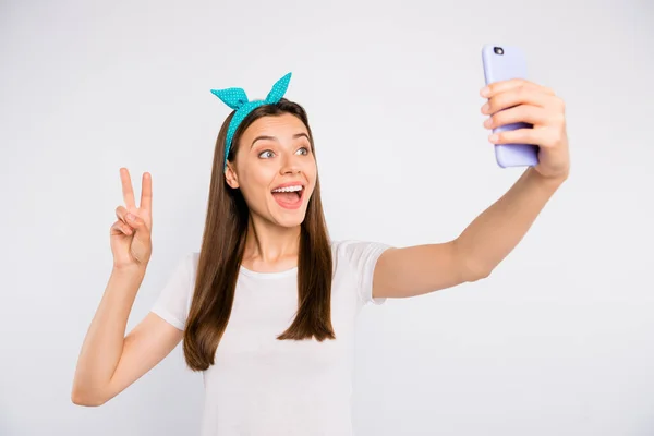 Portret podekscytowanej entuzjastycznej dziewczyny czuć pozytywne radosne emocje zrobić selfie na jej smartfonie V-sign powitać zwolenników bloga nosić biały styl strój izolowany na białym tle koloru — Zdjęcie stockowe