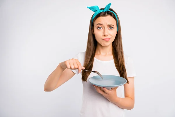 Close-up portrait of her she nice attractive lovely disappointed girl holding in hands empty plate fork punishment hunger isolated over light white color background — Stock Image Close-up portrait of her she nice attractive lovely disappointed girl holding in hands empty plate fork punishment hunger isolated over light white color background Stock Picture