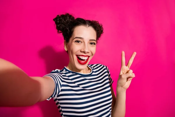 Auto foto de alegre linda novia fascinante agradable que muestra v-signo de tomar selfie regocijo sonriendo toothily aislado sobre fondo de color vivo rosa —  Fotos de Stock