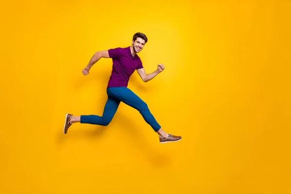 Full lenghtb rozmiar ciała boczny profil zdjęcie pośpiechu pilny biały casual facet działa skoków w niebieskie spodnie fioletowy t-shirt obuwie izolowane na żywe tło kolor — Zdjęcie stockowe