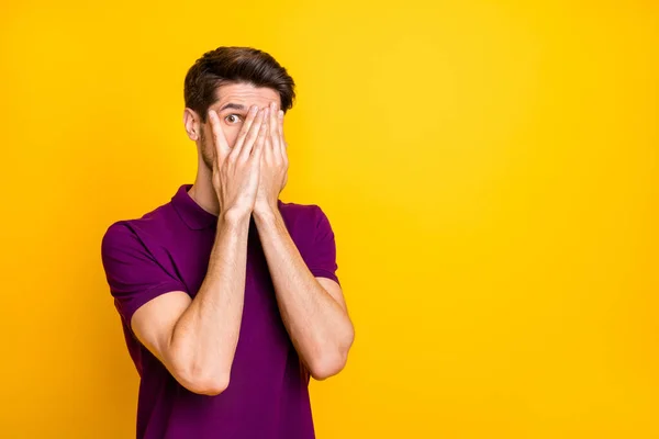 Portrait of his he nice atrakted scared guy wearing violet shirt hiding face in palms peeking isolated on bright vivid shine vibrant yellow color background — Stok Foto