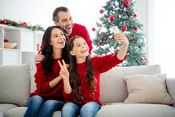 Πορτρέτο των τριών ωραία ελκυστική όμορφη θετική χαρούμενη χαρούμενη χαρούμενη ενθουσιασμένοι οικογένεια κάθεται σε ντιβάνι λήψη selfie αναψυχής δείχνει v-σημάδι αισιοδοξία στο φως λευκό εσωτερικό σαλόνι — Φωτογραφία Αρχείου