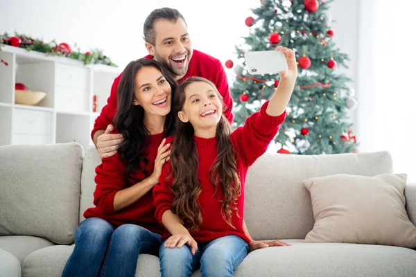 Portret van drie mooie mooie mooie positieve vrolijke vrolijke schattige schattige dromerige familie zitten op divan nemen maken selfie vrije tijd vakantie vrije tijd licht wit interieur kamer — Stockfoto