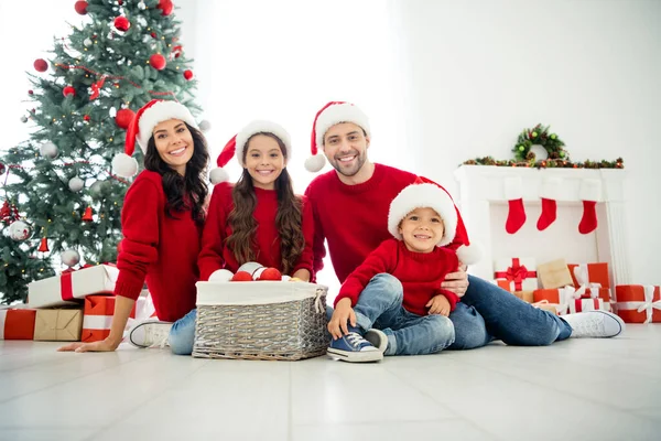 Retrato de quatro agradável atraente adorável alegre sonhador amigável grande completo família adotiva gastos celebrando newyear sentado no chão desfrutando de lazer em luz branca interior quarto dentro de casa — Fotografia de Stock