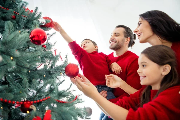 Profile side view portrait of four nice attractive lovely kind affectionate cheerful cheery friendly family celebrating newyear decorating evergreen tradition in light white interior room background — Stock Photo, Image