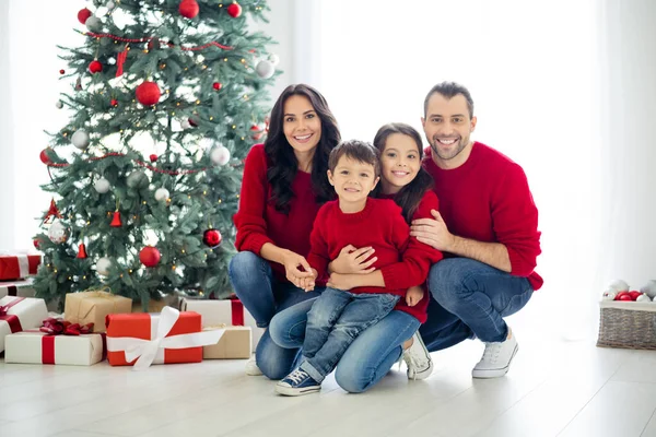 Volledige grootte foto van grote volledige familie mooie moeder vader schoolmeisje knuffel zitten in de buurt geschenk doos cadeau voor kerst tijd x-mas vakantie in huis binnen — Stockfoto