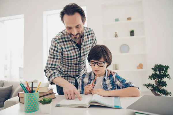 Otthoni feladat a legjobb apakomplexussal. Fénykép két ember pozitív beteg intelligens apa segíti utódai házi feladat előkészítése és tesztek — Stock Fotó