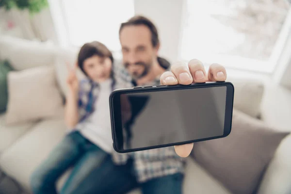 Közelkép fotó portré a pozitív nyugodt szép boldog apa, hogy szelfi a fiatalabb fia telefonon ül kényelmes kanapén pihenő hétvégén a nappaliban ház — Stock Fotó