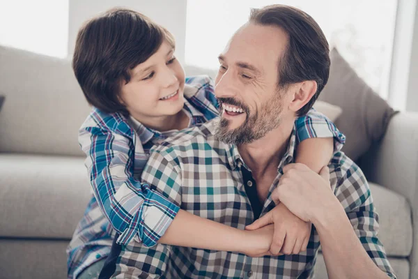 Close-up portrait of two nice attractive tender cheerful cheery glad guys dad daddy and pre-teen son hugging spending day at light white modern style interior house living-room indoors — Stock Photo, Image