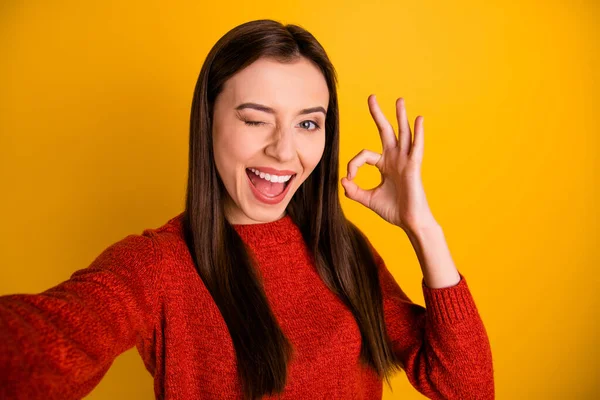 Närbild foto av glada positiva glada flicka känner glädje på semester turism semester gör selfie show ok tecken rekommendera resa bära bra utseende tröja isolerad över gul färg bakgrund — Stockfoto