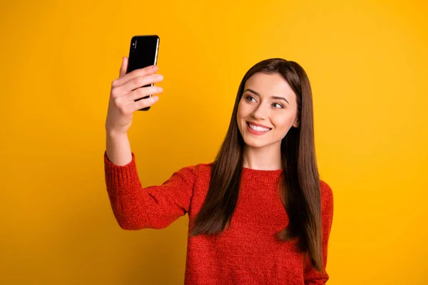 Çekici, büyüleyici, çekici bir kızın, özçekim videosu çektiği fotoğraf. Sarı renkli arka planda, dişe dokunur bir şekilde izole edilmiş gülümsüyor. — Stok fotoğraf