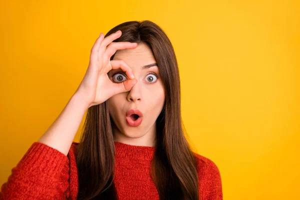 De cerca la foto de la chica asombrada con su signo bien cerca de ojo mira como espía ver anuncios increíbles sentir estupor expresión de la cara desgaste suéter rojo aislado sobre fondo de color amarillo —  Fotos de Stock