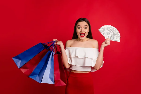 Portrait of lovely person holding bags earning screaming wow omg dressed white off-shoulders isolated over red background — Stock Photo, Image