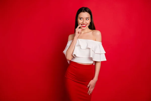 Retrato de una señora magnífica que tiene pensamientos con los dedos tocando los dientes meditando usando hombros aislados sobre el fondo rojo —  Fotos de Stock