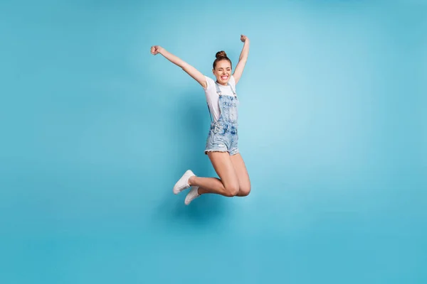 Ganzkörpergröße Foto von Mädchen springen mit Freude zu Fuß auf Luft, während isoliert mit blauem Hintergrund — Stockfoto