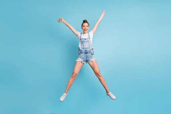 Volledige lichaamslengte foto van charmante fascinerende genieten positieve meisje stretching weg terwijl geïsoleerd met blauwe achtergrond — Stockfoto